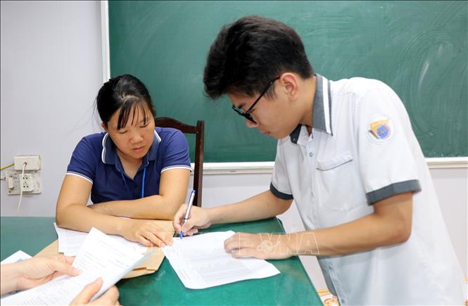 Thí sinh ký xác nhận làm thủ tục dự thi. Ảnh: Nguyễn Lành - TTXVN 