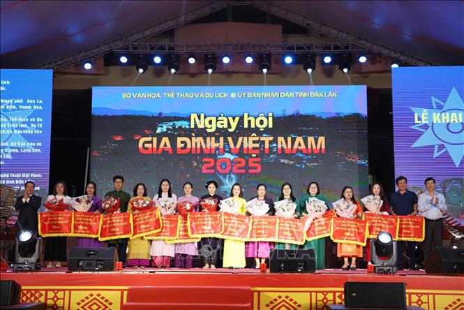 Ban Tổ chức trao cờ lưu niệm cho các đoàn tham gia “Ngày hội Gia đình Việt Nam năm 2025”. Ảnh: Hoài Thu – TTXVN.