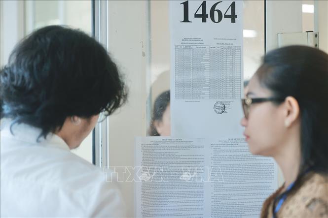 Giám thị gọi thí sinh vào phòng thi tại điểm thi Trường THPT Nguyễn Gia Thiều (Long Biên, Hà Nội). Ảnh: Minh Quyết - TTXVN