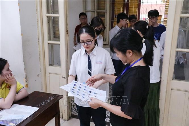 Kiểm tra thông tin thí sinh trước khi vào phòng thi tại điểm trường THPT Trần Phú (quận Hoàn Kiếm). Ảnh: Khánh Hoà - TTXVN