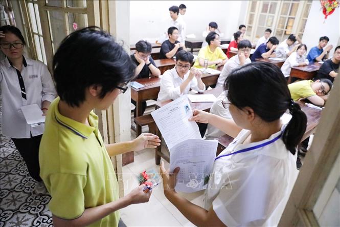 Kiểm tra thông tin thí sinh trước khi vào phòng thi tại điểm thi Trường THPT Trần Phú (quận Hoàn Kiếm, Hà Nội). Ảnh: Khánh Hoà - TTXVN