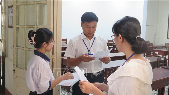 Giám thị gọi thí sinh vào phòng thi. Ảnh: Tường Vi - TTXVN 
             