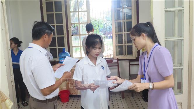  Giám thị gọi thí sinh vào phòng thi. Ảnh: Tường Vi - TTXVN                               
