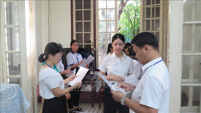 Giám thị gọi thí sinh vào phòng thi. Ảnh: Tường Vi- TTXVN 