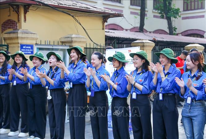 Thanh niên tình nguyện khích lệ tinh thần thí sinh tại điểm trường THPT Trần Phú (quận Hoàn Kiếm). Ảnh: Khánh Hoà - TTXVN