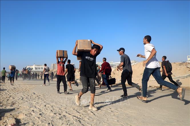Người dân Palestine nhận hàng cứu trợ tại Gaza. Ảnh: THX/TTXVN