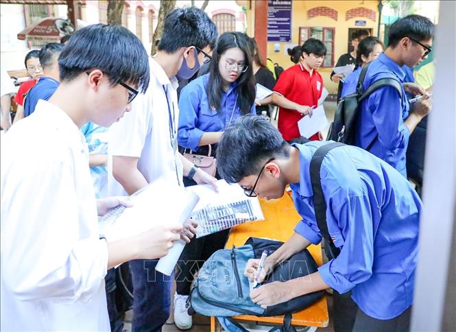 Thanh niên tình nguyện hỗ trợ thí sinh gửi đồ bên ngoài phòng thi tại điểm trường THPT Trần Phú (quận Hoàn Kiếm). Ảnh: Khánh Hoà - TTXVN