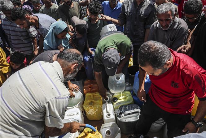 Người dân Palestine lấy nước sinh hoạt tại trại tị nạn ở Gaza. Ảnh: THX/TTXVN