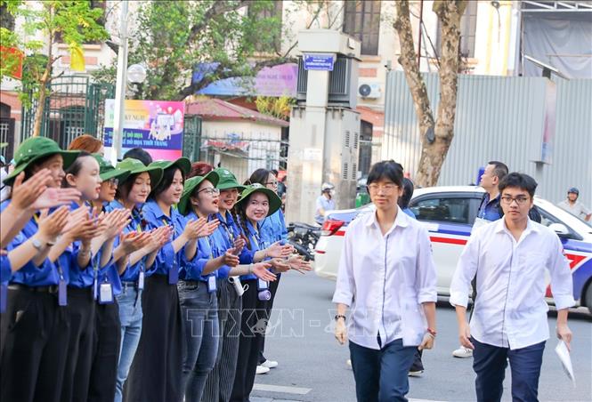 Thanh niên tình nguyện khích lệ tinh thần thí sinh tại điểm trường THPT Trần Phú (quận Hoàn Kiếm). Ảnh: Khánh Hoà - TTXVN