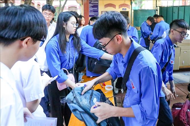 Thanh niên tình nguyện hỗ trợ thí sinh gửi đồ bên ngoài phòng thi tại điểm trường THPT Trần Phú (quận Hoàn Kiếm). Ảnh: Khánh Hoà - TTXVN