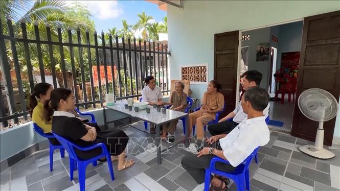 Local authorities and villagers visit a 87-year-old woman in her new house in Hanh Duc commune, Nghia Hanh district. VNA Photo: Hải Âu