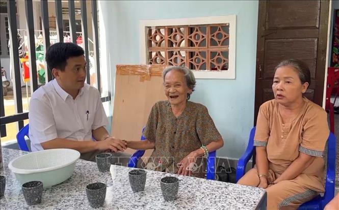 Local authorities and villagers visit a 87-year-old woman in her new house in Hanh Duc commune, Nghia Hanh district. VNA Photo: Hải Âu
