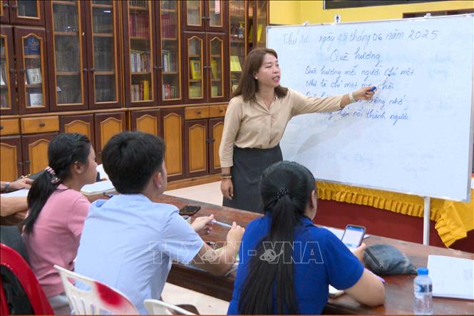 Chị Nguyễn Thị Thu Huyền hướng dẫn các học viên là con em kiều bào và người Lào học hát ca khúc Quê Hương. Ảnh: Đỗ Bá Thành. PV TTXVN tại Lào