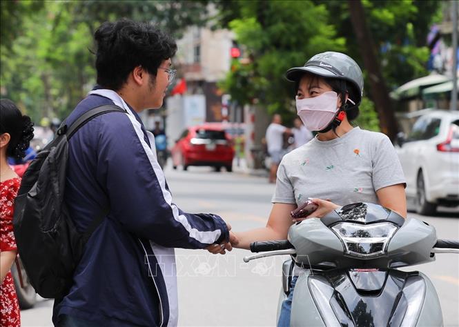 Chúc con trai đạt được kết quả tốt trước khi vào phòng thi tại điểm trường THCS Ngô Sĩ Liên (quận Hoàn Kiếm). Ảnh: Khánh Hoà - TTXVN