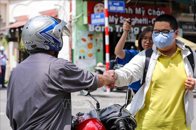 Cái bắt tay chặt của bố động viên con trước kỳ thi quan trọng của cuộc đời. Ảnh: Khánh Hoà - TTXVN
