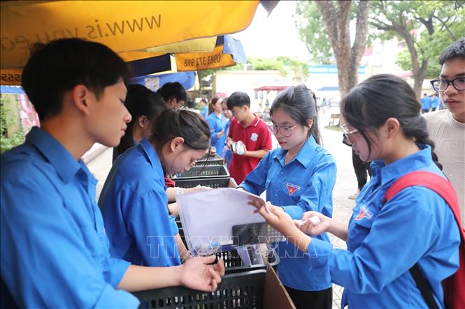Sinh viên tình nguyện hỗ trợ thí sinh tại điểm thi Trường THPT Nguyễn Gia Thiều (Long Biên, Hà Nội). Ảnh: Thành Phương - TTXVN