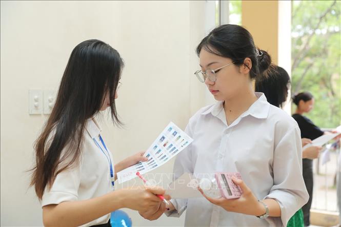 Giám thị gọi thí sinh vào phòng thi tại điểm thi Trường THPT Nguyễn Gia Thiều (Long Biên, Hà Nội). Ảnh: Thành Phương - TTXVN