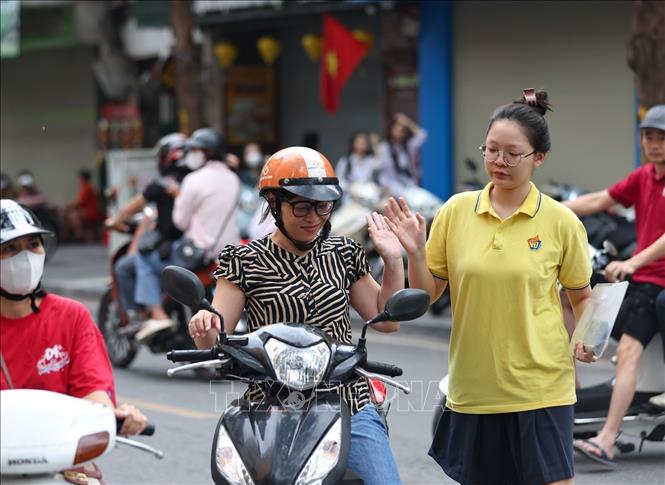 Tạm biệt người thân cùng những vật dụng ko được phép mang vào phòng thi, thí sinh vui vẻ bước vào buổi thi cuối. Ảnh: Thanh Tùng - TTXVN