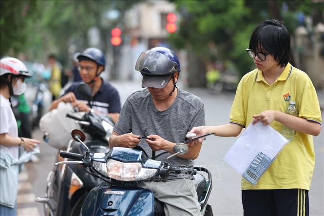 Tạm biệt người thân cùng những vật dụng không được phép mang vào phòng thi, thí sinh vui vẻ bước vào buổi thi cuối. Ảnh: Thanh Tùng - TTXVN
