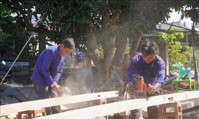 Thành viên Tổ cất nhà từ thiện xã Tân Thạnh, huyện Thanh Bình, giúp những hộ nghèo, cận nghèo xây dựng nhà mới. Ảnh: Nhựt An - TTXVN