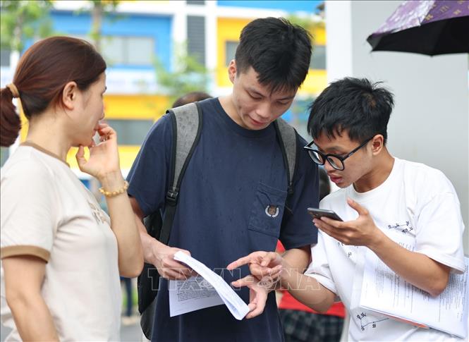 Thí sinh trao đổi về bài làm môn Ngoại ngữ. Ảnh: Thanh Tùng - TTXVN