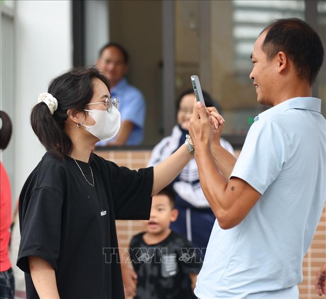 Người thân ghi lại cảm xúc kết thúc kỳ thi khi đón thí sinh. Ảnh: Thanh Tùng - TTXVN