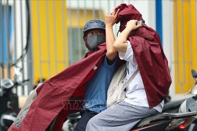 Thời tiết Hà Nội xuất hiện mưa một vài nơi, nhiều phụ huynh đón con hoàn thành kỳ thi trong mưa. Ảnh: Thanh Tùng - TTXVN