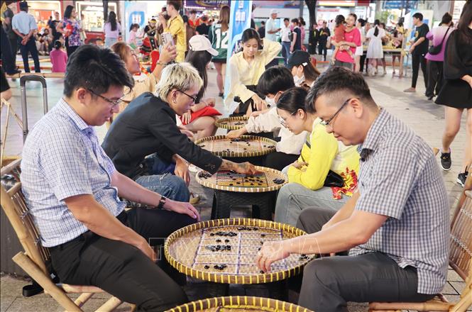 Người dân trải nghiệm trò chơi dân gian. Ảnh: Thu Hương - TTXVN