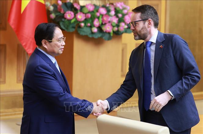 Thủ tướng Phạm Minh Chính và Đại sứ Vương quốc Anh tại Việt Nam Iain Frew. Ảnh: Dương Giang-TTXVN 
