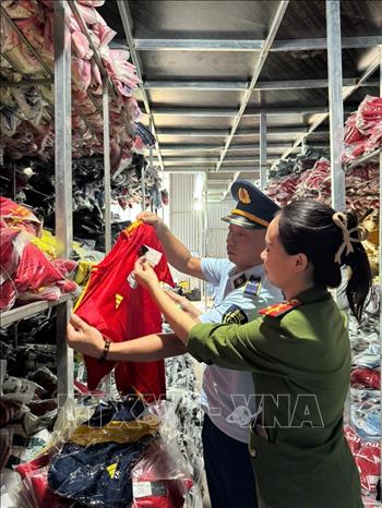 Một số lượng lớn quần áo mang nhãn hiệu NIKE, ADIDAS, PUMA bị lực lượng chức năng phát hiện. Ảnh: TTXVN phát