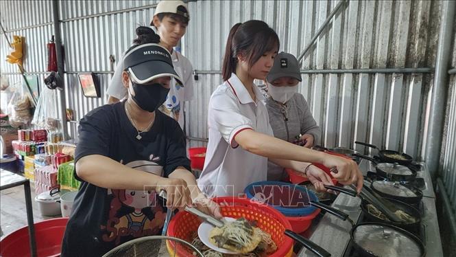 Sau khi đánh bắt cá, du khách được trực tiếp nấu bánh xèo cá kình - món ăn đặc sản của điểm đến Đầm Chuồn. Ảnh: Mai Trang - TTXVN 