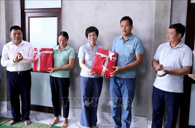 Tổng Giám đốc TTXVN Vũ Việt Trang tặng quà cho gia đình được TTXVN hỗ trợ xây dựng nhà mới. Ảnh: Quang Cường - TTXVN
