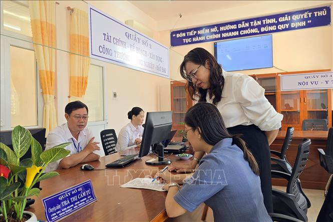 Cán bộ Trung tâm phục vụ hành chính công phường An Xuyên (mới), tỉnh Cà Mau trực tiếp hướng dẫn người dân đăng ký thực hiện thủ tục hành chính. Ảnh: Kim Há – TTXVN