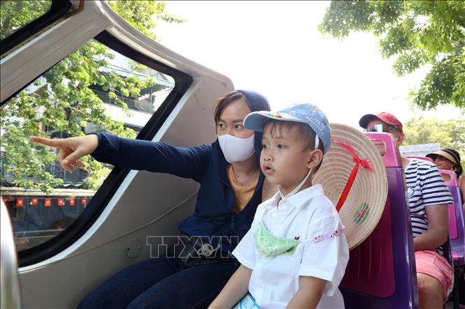 Bé Nguyễn Việt Quang (5 tuổi), quê Lâm Đồng, được mẹ cho đi khám phá Thành phố Hồ Chí Minh bằng xe bus hai tầng.  Ảnh: Hồng Đạt - TTXVN
