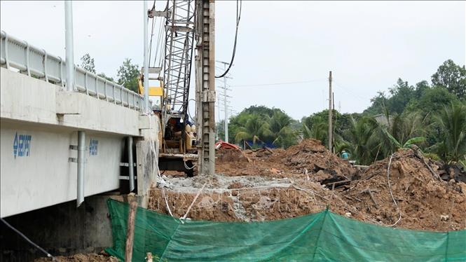 Ép cọc gia cố phần đường dẫn vào cầu Hòa Bình. Ảnh: Thanh Tân – TTXVN