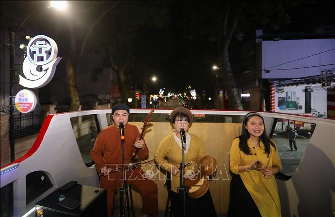 Du khách vừa được ngắm nhìn những danh thắng thủ đô lung linh về đêm, vừa được thưởng thức trực tiếp những làn điệu Xẩm. Ảnh: Khánh Hoà - TTXVN