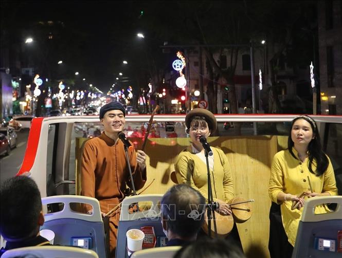 Các bạn trẻ Nhóm xẩm 48h biểu diễn trên xe bus 2 tầng. Ảnh: Khánh Hoà - TTXVN