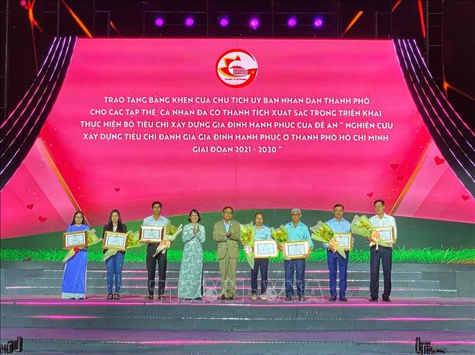 Trao Bằng khen của Chủ tịch UBND Thành phố cho các tập thể, cá nhân đã có thành tích xuất sắc trong triển khai, thực hiện Bộ tiêu chí xây dựng gia đình hạnh phúc của Đề án “Nghiên cứu xây dựng tiêu chí đánh giá gia đình hạnh phúc ở Thành phố Hồ Chí Minh giai đoạn 2021 – 2030”. Ảnh: Hồng Giang - TTXVN. 