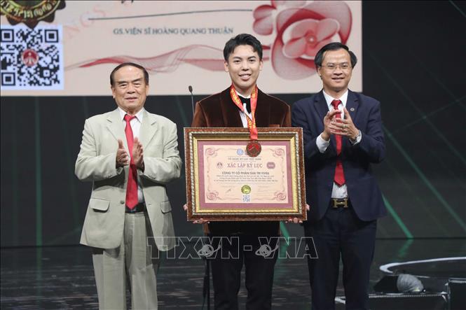 Ông Phạm Duy Khánh, Trưởng Ban tổ chức đón nhận kỷ lục phần trình diễn có số lượng trang phục làm từ nguyên liệu tái chế nhiều nhất. Ảnh: Hoàng Ngọc – TTXVN 