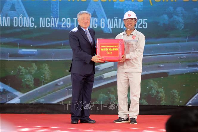 Phó Thủ tướng Thường trực Chính phủ Nguyễn Hòa Bình tặng quà cho công nhân thi công dự án cao tốc. Ảnh: Chu Quốc Hùng - TTXVN
