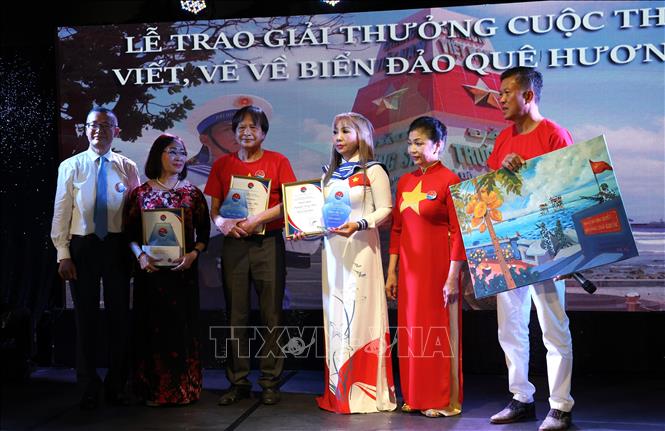 Đại sứ Vũ Quang Minh (ngoài cùng bên trái) trao Giải Nhất cho ba thí sinh dự thi ở các thể loại văn xuôi, thơ và tranh vẽ. Ảnh: Thu Hằng-PV TTXVN tại Đức