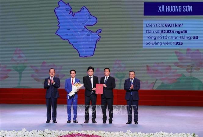 Đồng chí Trần Sỹ Thanh (bên phải), Ủy viên Trung ương Đảng, Phó Bí thư Thành ủy, Chủ tịch UBND thành phố Hà Nội và Phó Bí thư Thành ủy, Chủ tịch HĐND thành phố Hà Nội Nguyễn Ngọc Tuấn trao Quyết định của BCH Đảng bộ thành phố cho Đảng bộ xã Hương Sơn. Ảnh: Văn Điệp – TTXVN