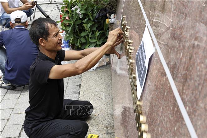Công nhân đơn vị thi công gắn biển trụ sở phường Ngọc Hà, thành phố Hà Nội. Ảnh: Lê Đông - TTXVN