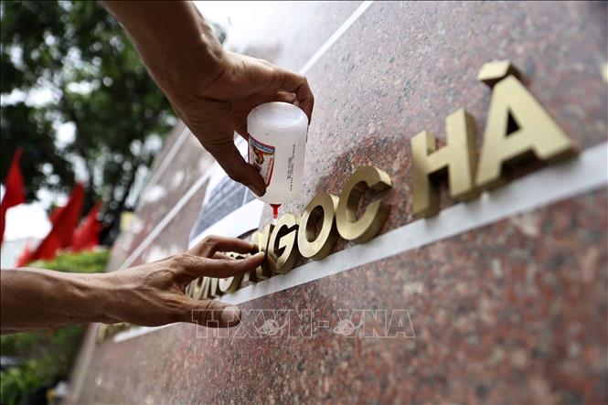 Công nhân đơn vị thi công gắn biển trụ sở phường Ngọc Hà, thành phố Hà Nội. Ảnh: Lê Đông - TTXVN