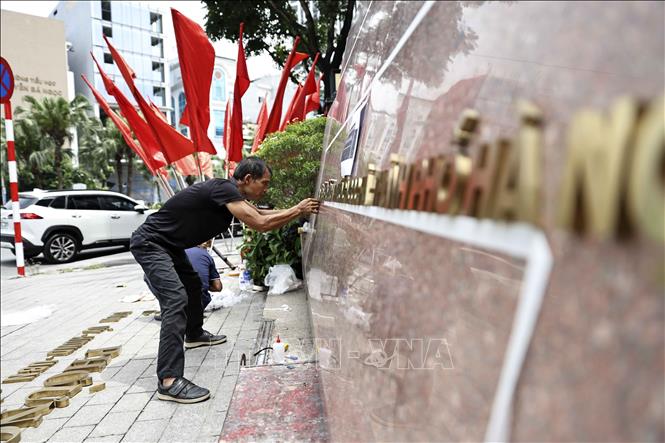 Công nhân đơn vị thi công gắn biển trụ sở phường Ngọc Hà, thành phố Hà Nội. Ảnh: Lê Đông - TTXVN