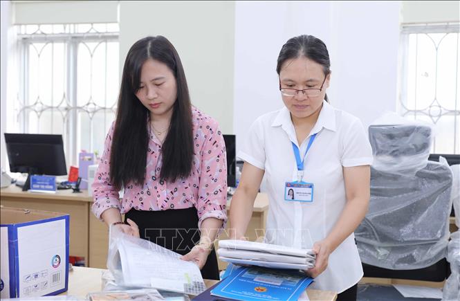 Nhân viên phường Long Biên hoàn tất việc chỉnh trang trụ sở, sẵn sàng cho lễ công bố vận hành chính quyền 2 cấp. Ảnh: Thành Phuơng – TTXVN