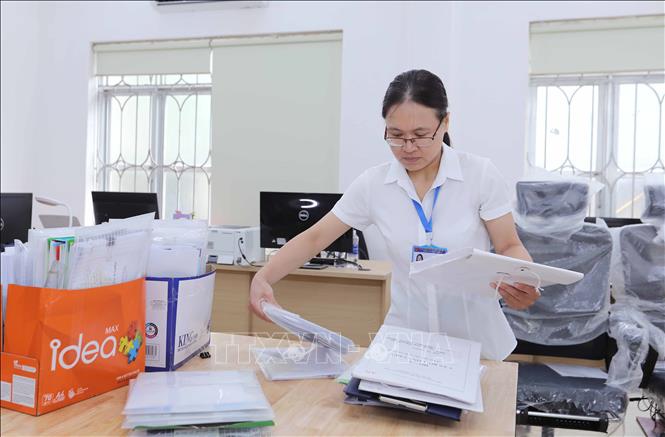 Nhân viên phường Long Biên hoàn tất việc chỉnh trang trụ sở, sẵn sàng cho lễ công bố vận hành chính quyền 2 cấp. Ảnh: Thành Phuơng – TTXVN