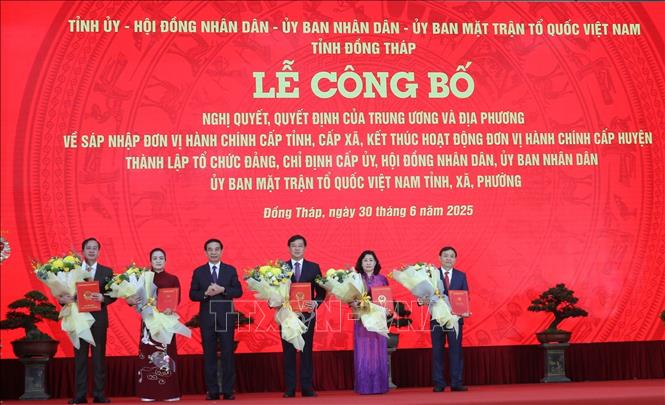 Đồng chí Phan Văn Giang, Ủy viên Bộ Chính trị, Bộ trưởng Bộ Quốc phòng trao các Quyết định và tặng hoa chúc mừng lãnh đạo tỉnh Đồng Tháp. Ảnh: Đức Tâm – TTXVN