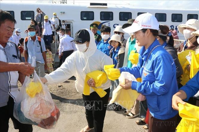 Tặng túi nilon tự hủy và tuyên truyền cho du khách không mang sản phẩm nhựa lên đảo Phú Quý, hướng đến loại bỏ hoàn toàn rác thải nhựa tại đảo. Ảnh: Nguyễn Thanh - TTXVN