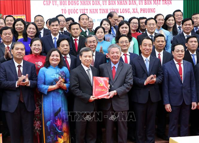 Chánh án Tòa án nhân dân tối cao Lê Minh Trí trao các nghị quyết, quyết định của Trung ương cho lãnh đạo tỉnh Vĩnh Long. Ảnh: Phạm Minh Tuấn-TTXVN.